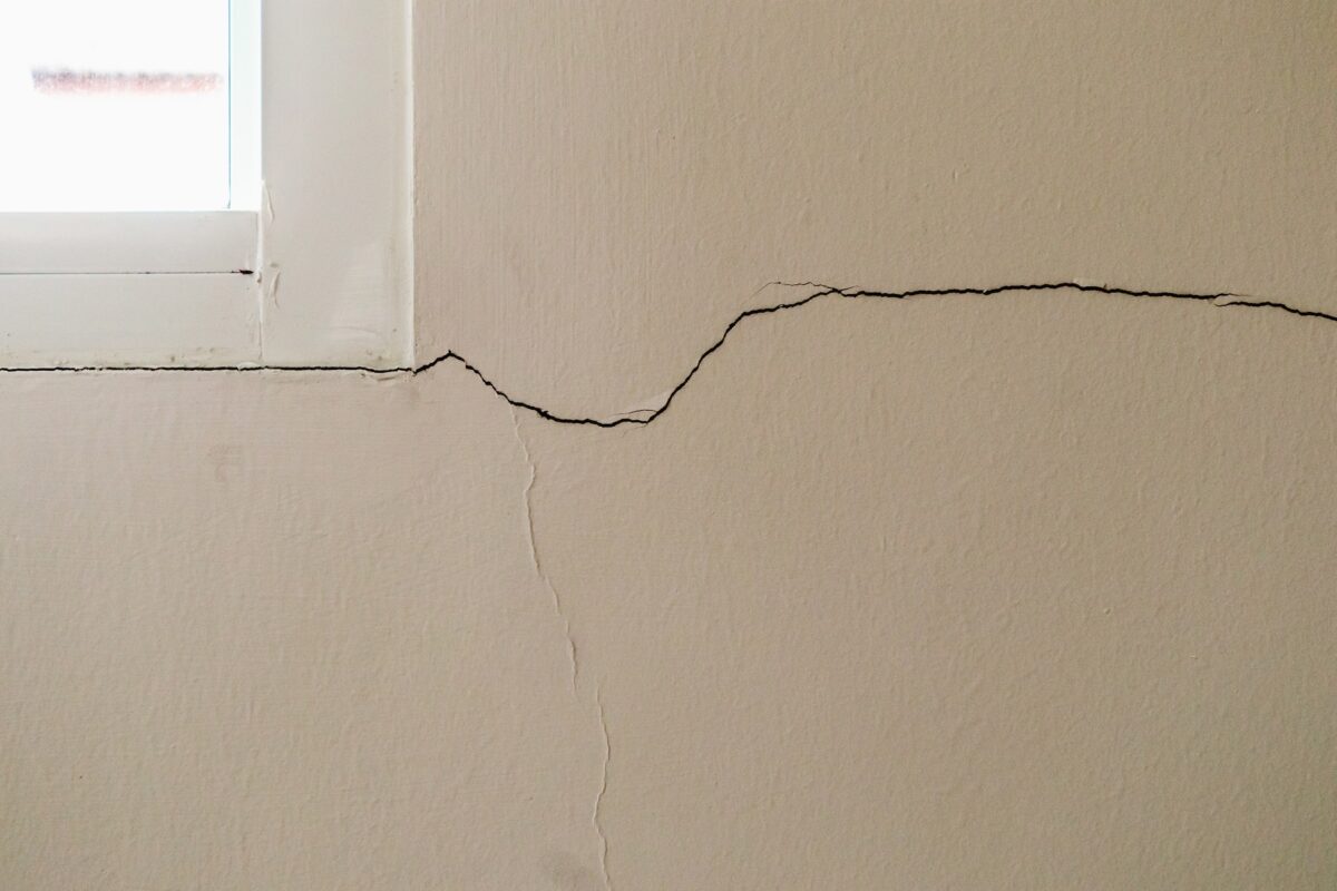 New, large crack in a wall coming from the corner of a window frame