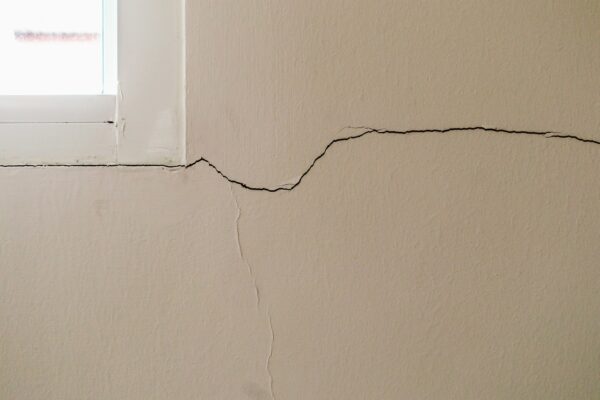 New, large crack in a wall coming from the corner of a window frame