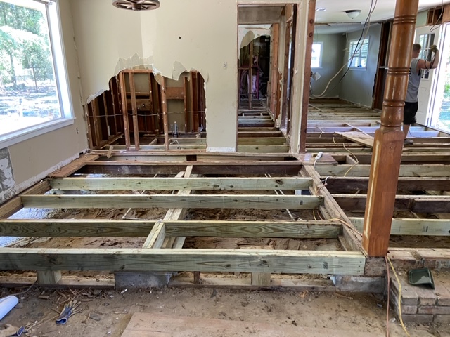 New wooden floor beams installed inside a home during a foundation repair