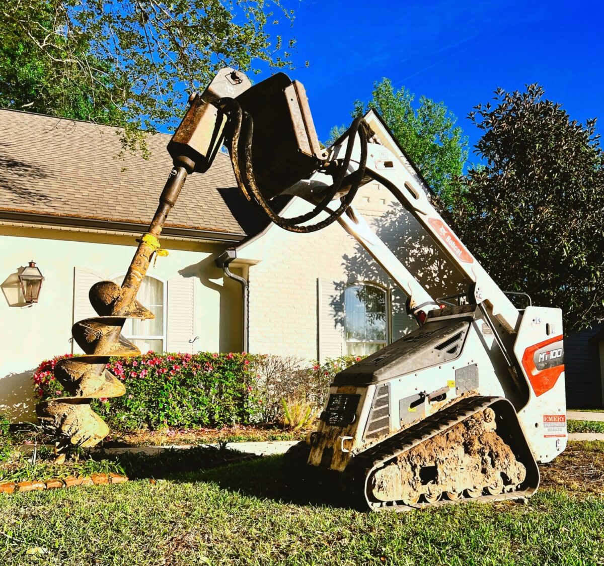 Industrial equipment drilling into grass for home foundation repair