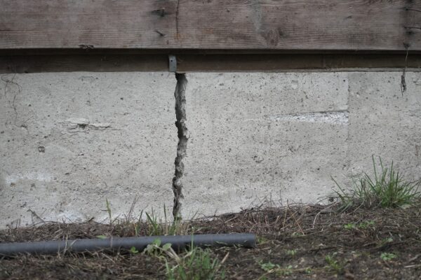 Close-up of a deep crack in a concrete home foundation