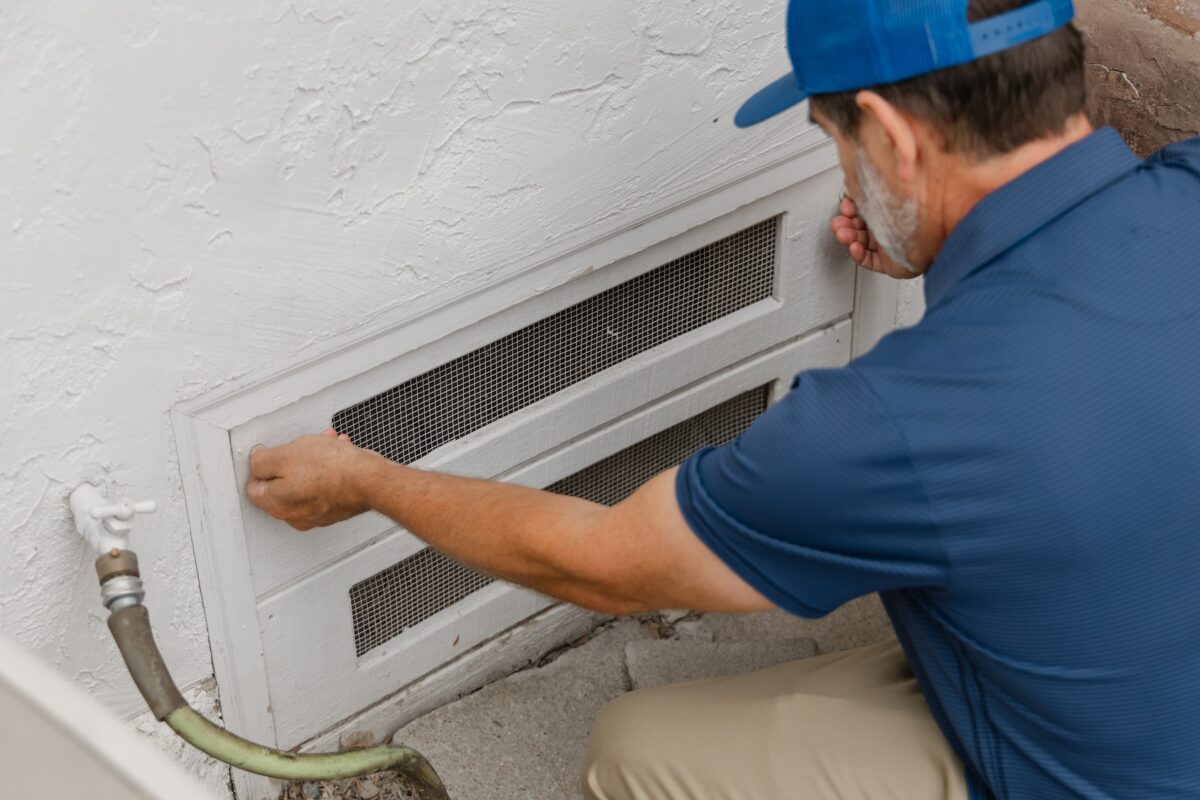 Foundation repair expert checks ventilation at crawl space